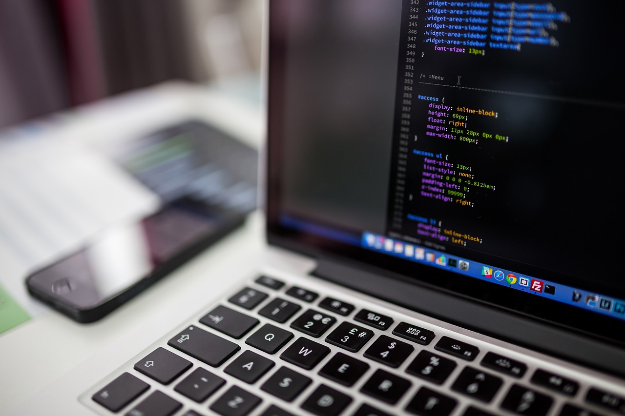 Developer writing TypeScript code on a laptop in a modern workspace