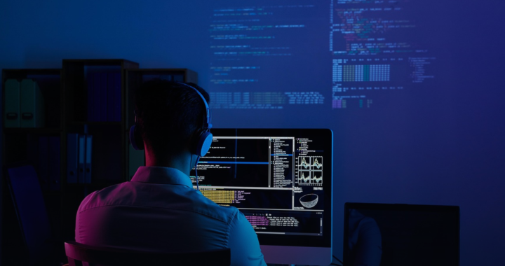 Developer working at a code-lit monitor, building software on AWS