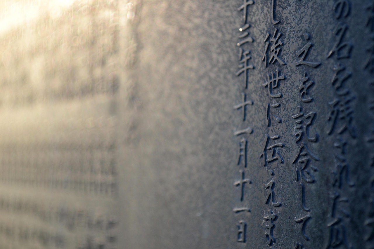 Japanese kanji characters carved into stone, lit by warm sunlight