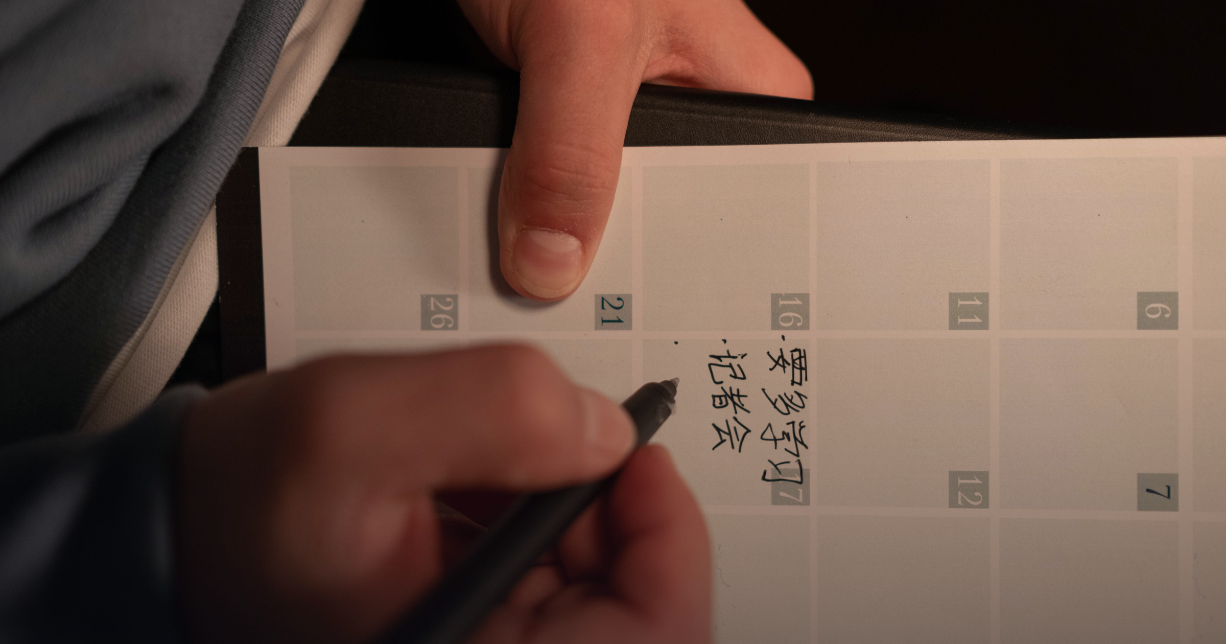 Hand writing Japanese characters in a planner with a pen