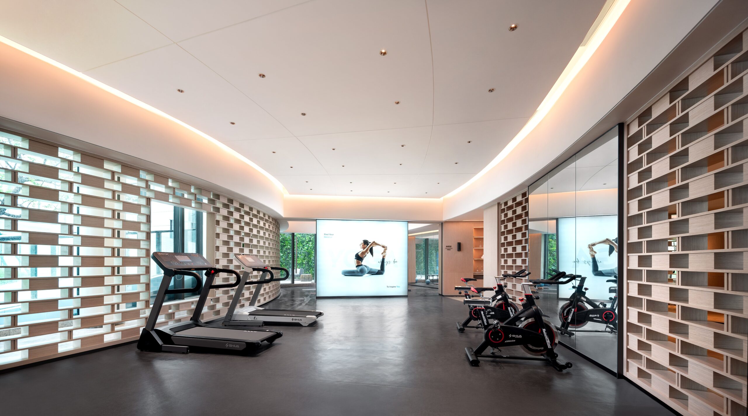 Modern gym interior with treadmills and stationary bikes in a clean, minimalist design