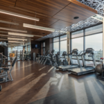 Modern 24-hour gym interior in Japan with cardio machines, weights, and a city-view window