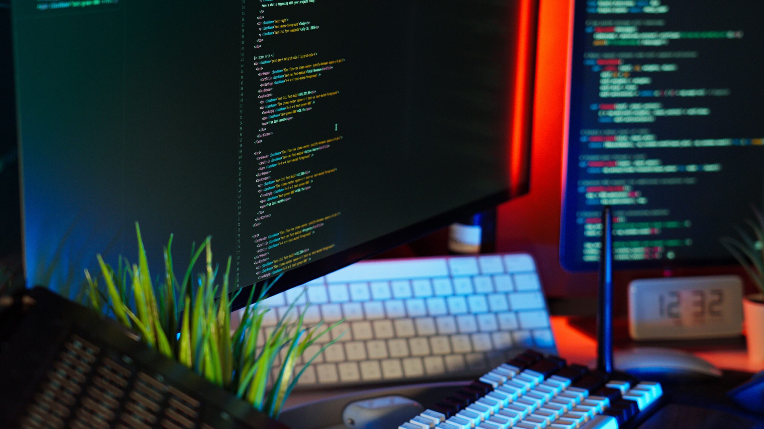 Dual-monitor developer workspace with code editors and ambient lighting