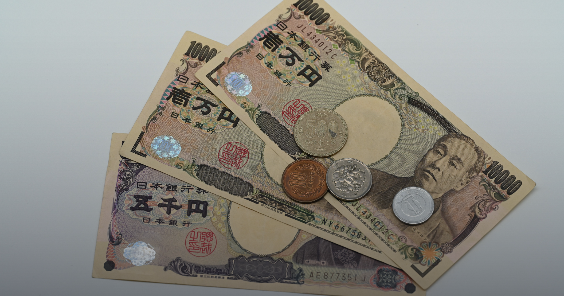 Japanese yen banknotes and coins arranged on a surface