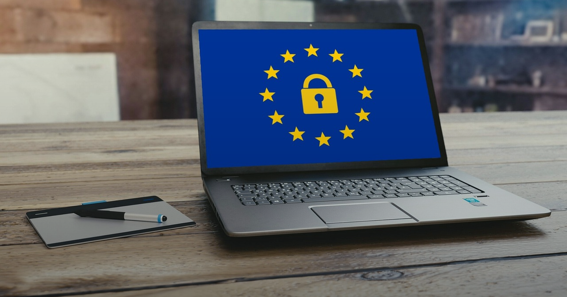 Laptop showing a padlock ringed by stars on a desk, symbolizing data privacy law