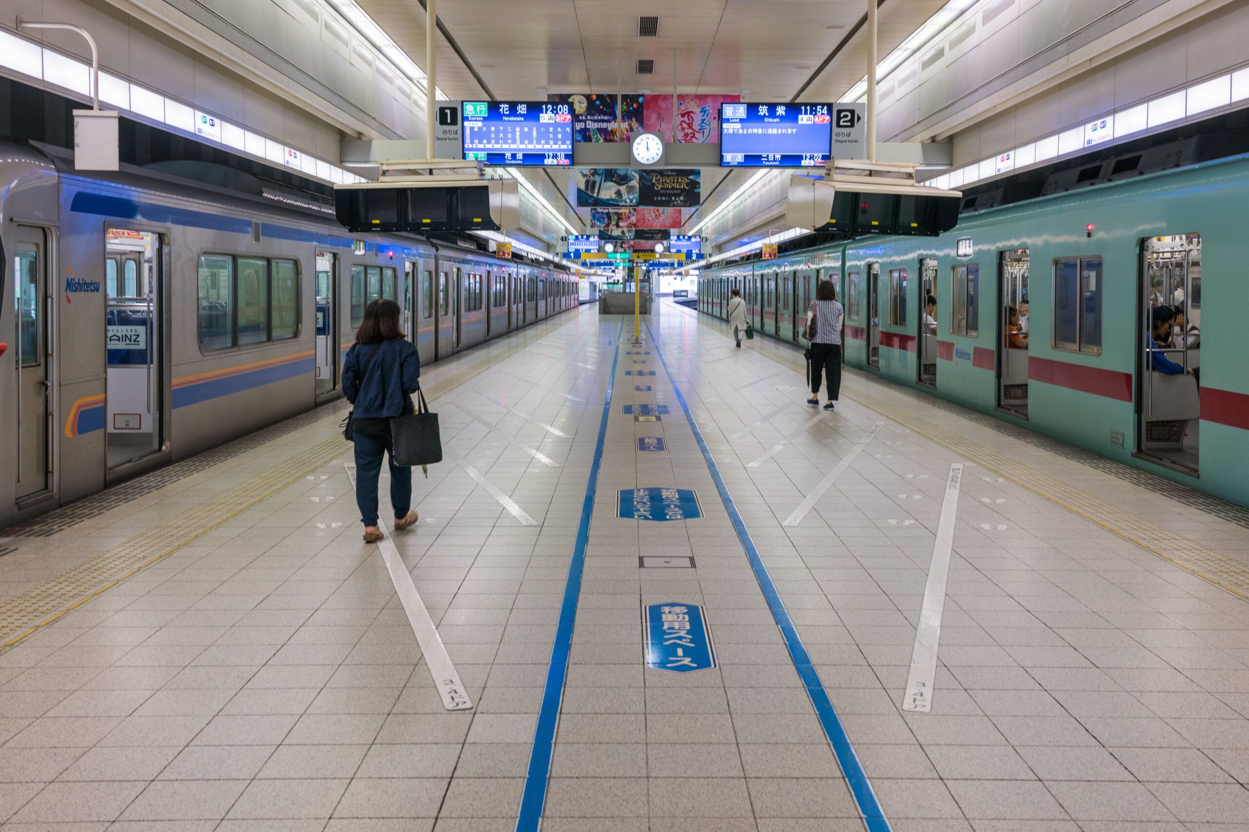 Commuters on a clean Japanese train station platform between two trains