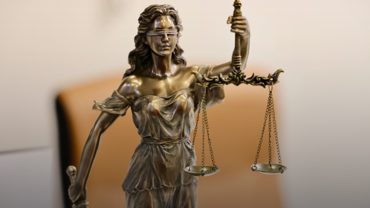 A bronze statue of Lady Justice holding scales and a sword