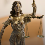 A bronze statue of Lady Justice holding scales and a sword
