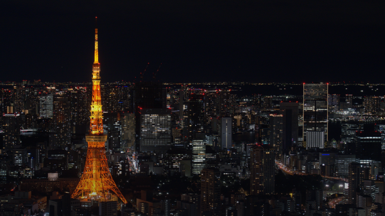 Tokyo Tower illuminated at night above the dense city skyline